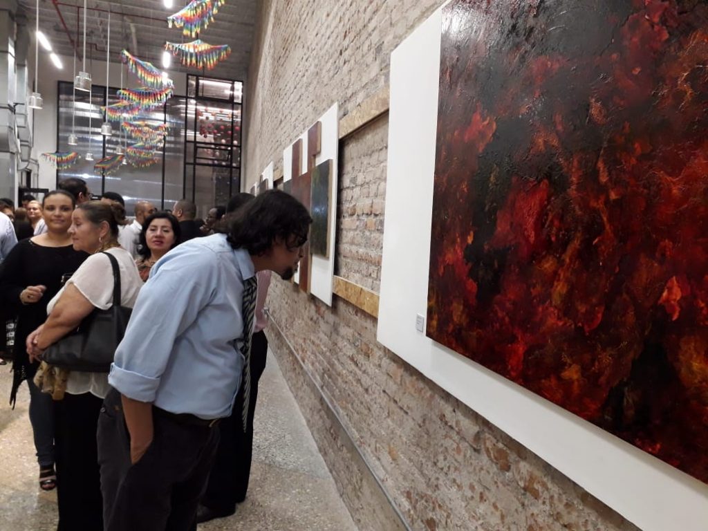 Hombre admirando una pintura en una galería