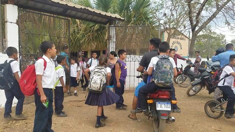 Con machete en mano, olanchana recoge a su niño en escuela en Catacamas