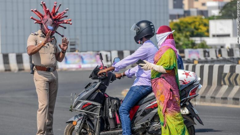 Coronavirus: oficial de la India lleva un casco de covid-19 para concienciar a la gente a quedarse en casa
