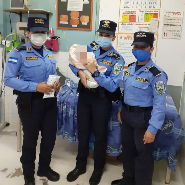Policía sostiene al bebé en sus brazos.