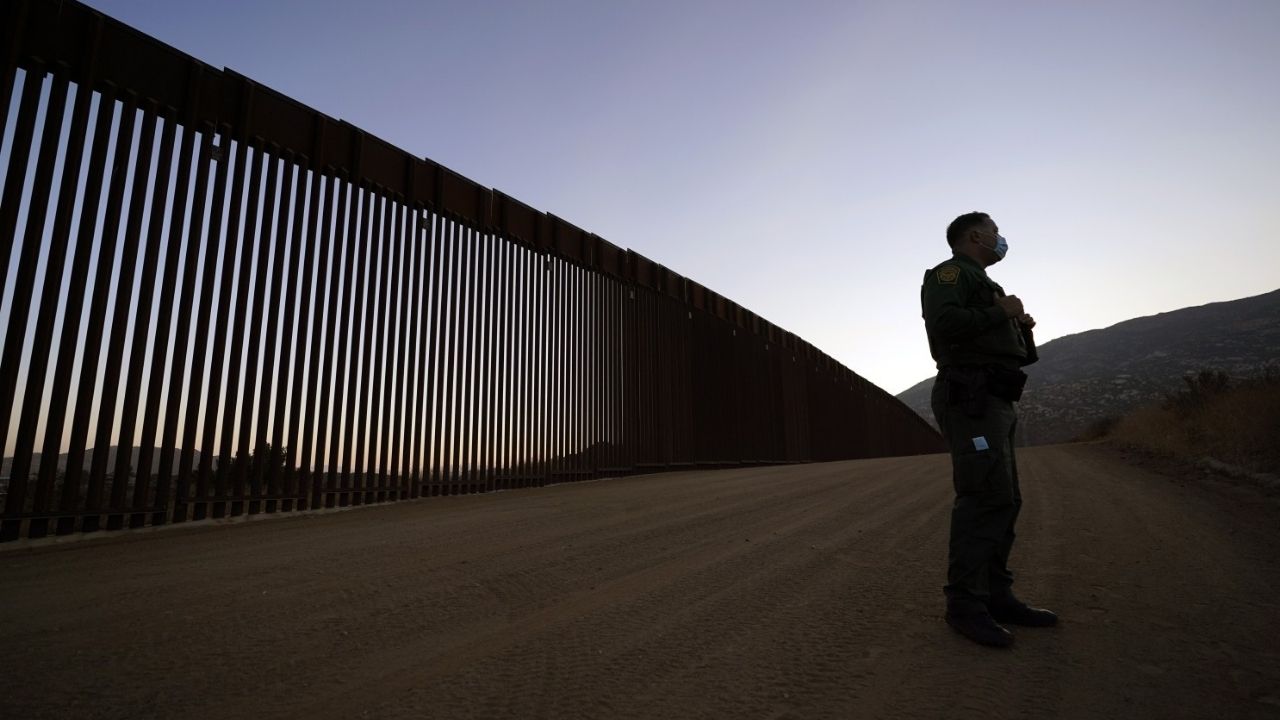 Mira cómo migrantes cruzan tranquilamente el muro fronterizo de Trump a través de una puerta