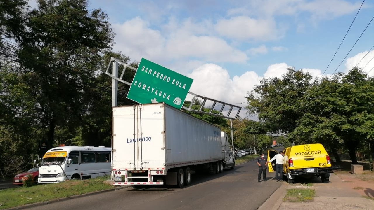 Inusual accidente: Vehículo impacta contra poste y ocasiona que señalización caiga sobre una rastra en Tegucigalpa