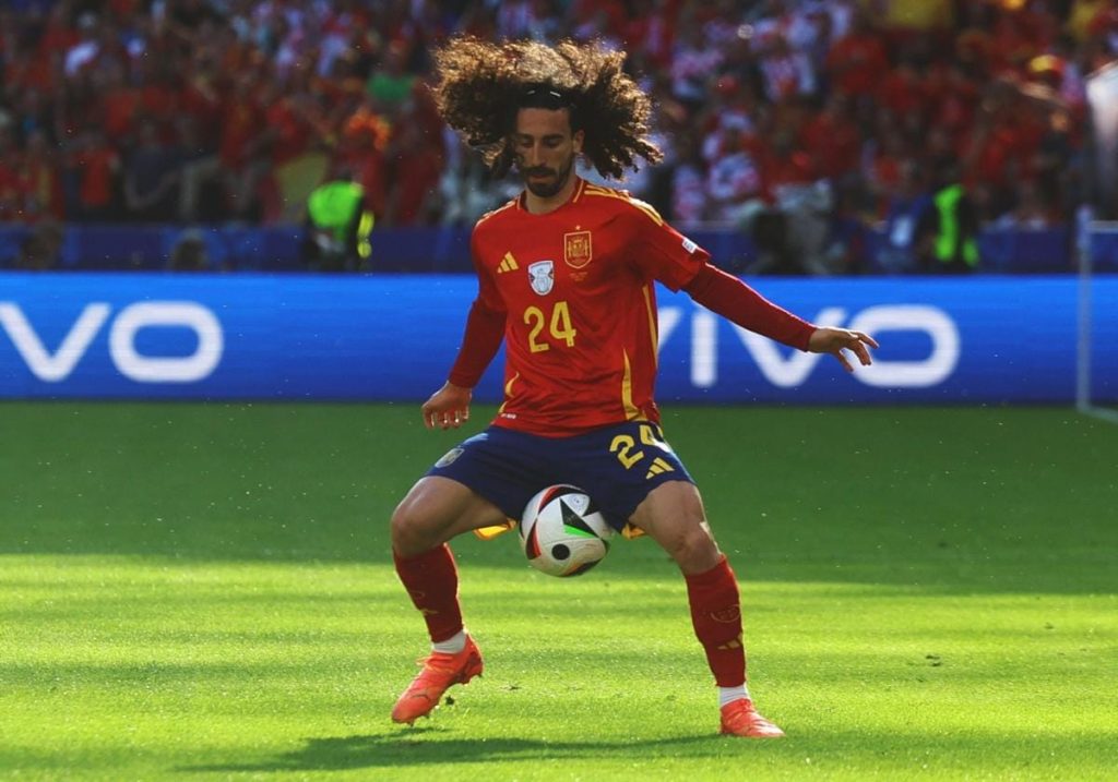 Cucurella dominando un balón en un campo de fútbol