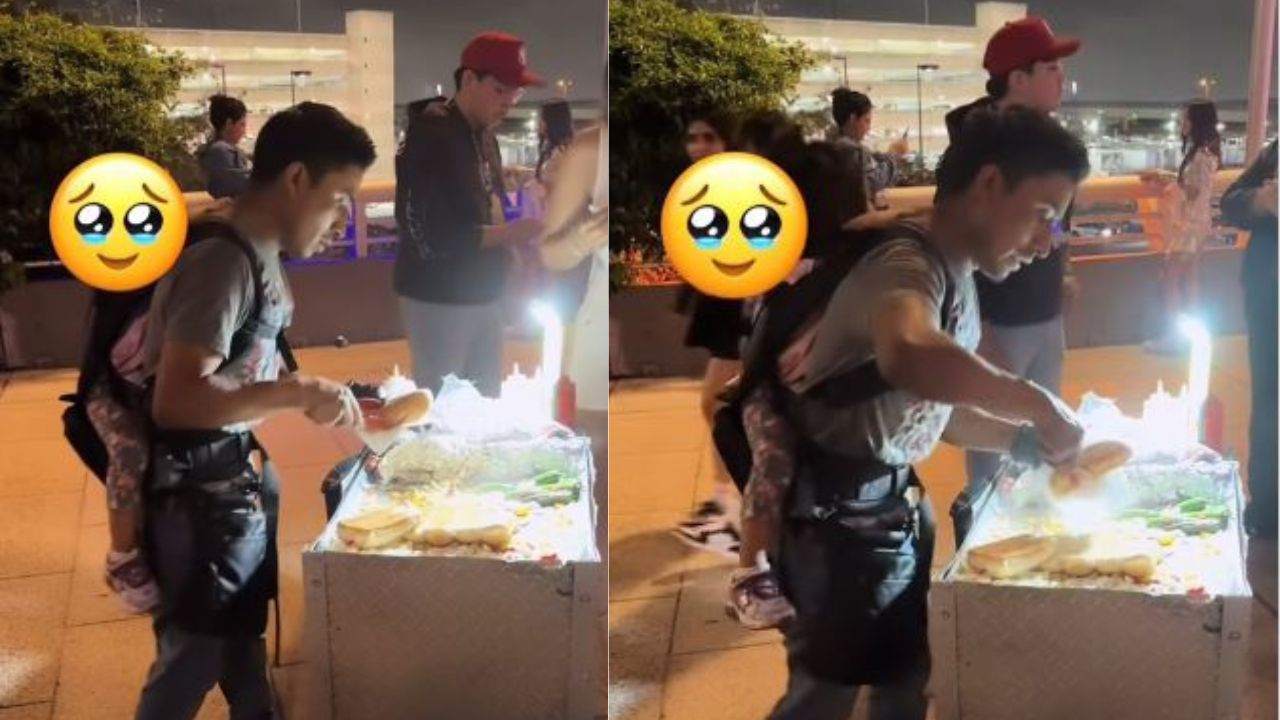 Con su hija en la espalda, hombre trabaja en venta de 'hot dog'