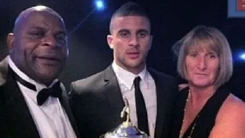 Kyle Walker vestido formalmente al igual que sus padres