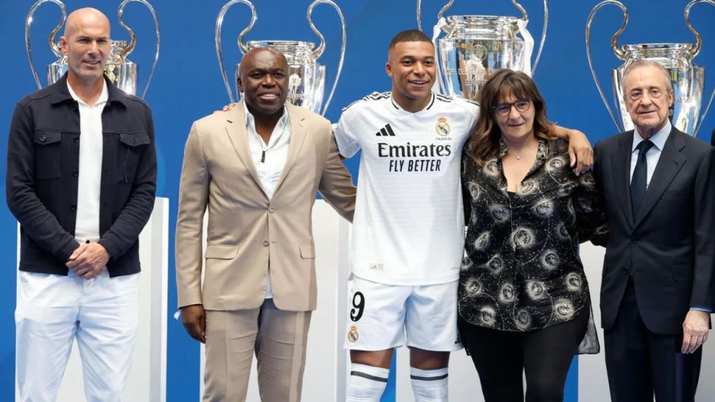 Kylian Mbappé en su presentación como futbolista de Real Madrid mientras abraza a sus padres y al lado Florentino Pérez y Zinedine Zidane