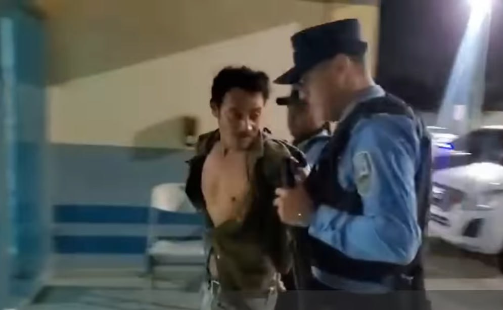 El hombre al lado de policías