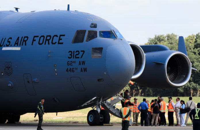 Personas al lado de un avión militar
