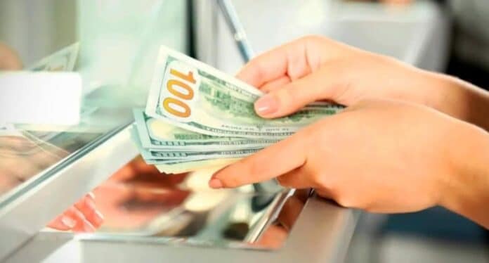 Unas manos recibiendo dólares