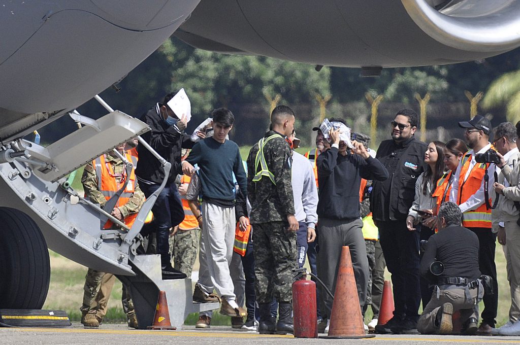 Personas deportadas llegan en un avión militar estadounidense.