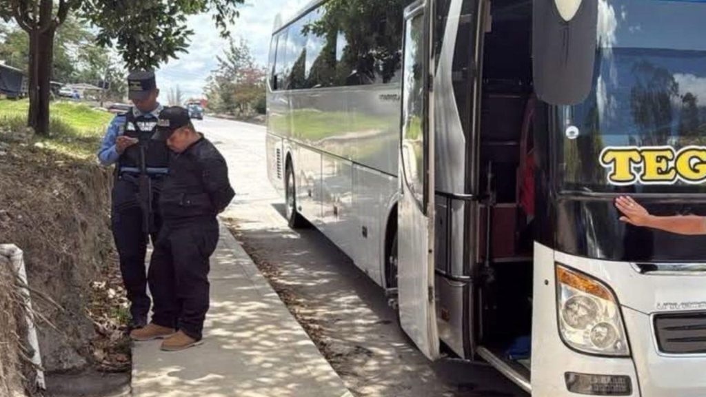 Policía deteniendo a un sujeto que bajaron de bus 