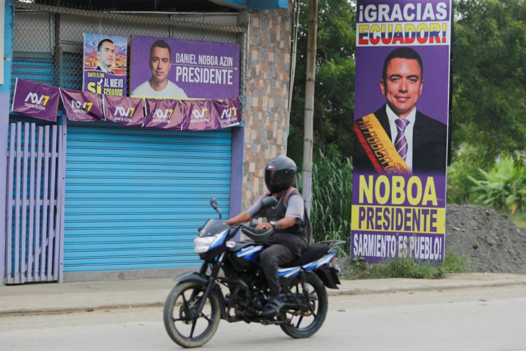 Motociclista frente a carteles de Daniel Noboa