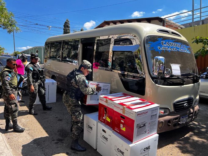 Militares cargando material electoral al lado de un bus