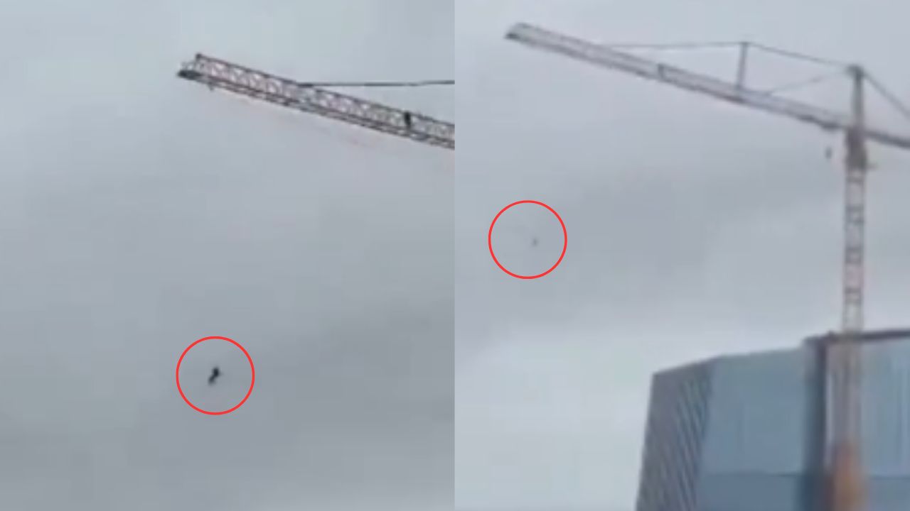 Graban a hombre columpiándose en grúa en construcción de edificio