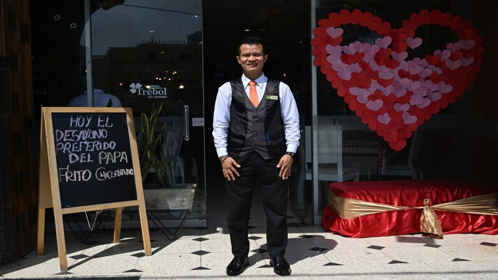 Joven frente a la entrada de restaurante donde comía el papa en Chiclayo
