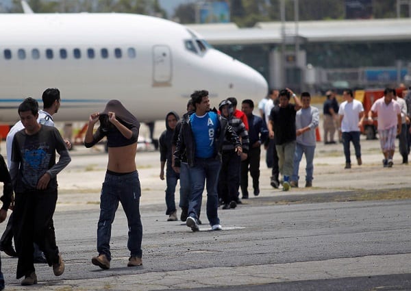 Migrantes cerca de un avión