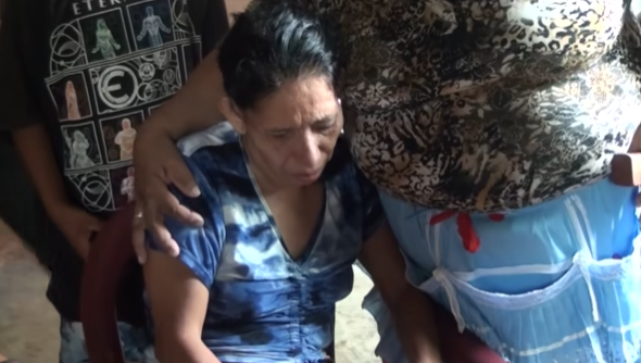 La madre abrazada por una mujer