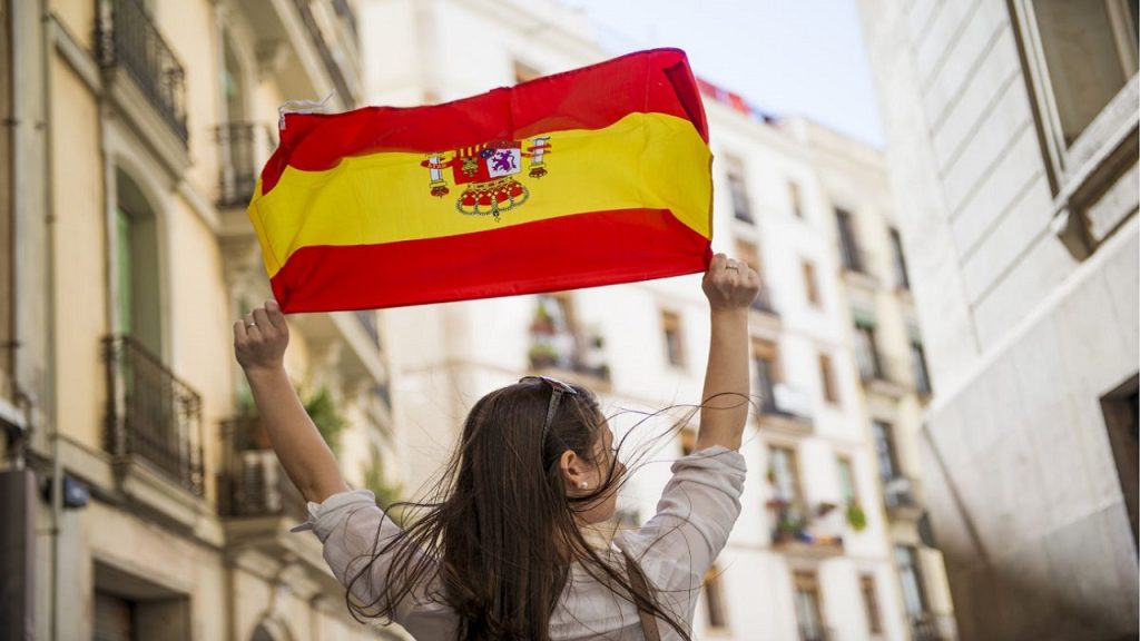 Una persona levantando la bandera de España