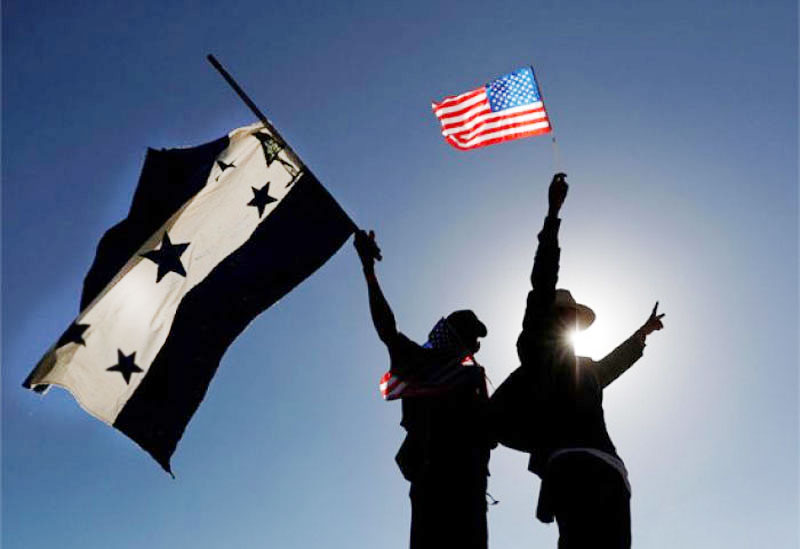 Sombras de personas levantando la bandera de Honduras y la de Estados Unidos