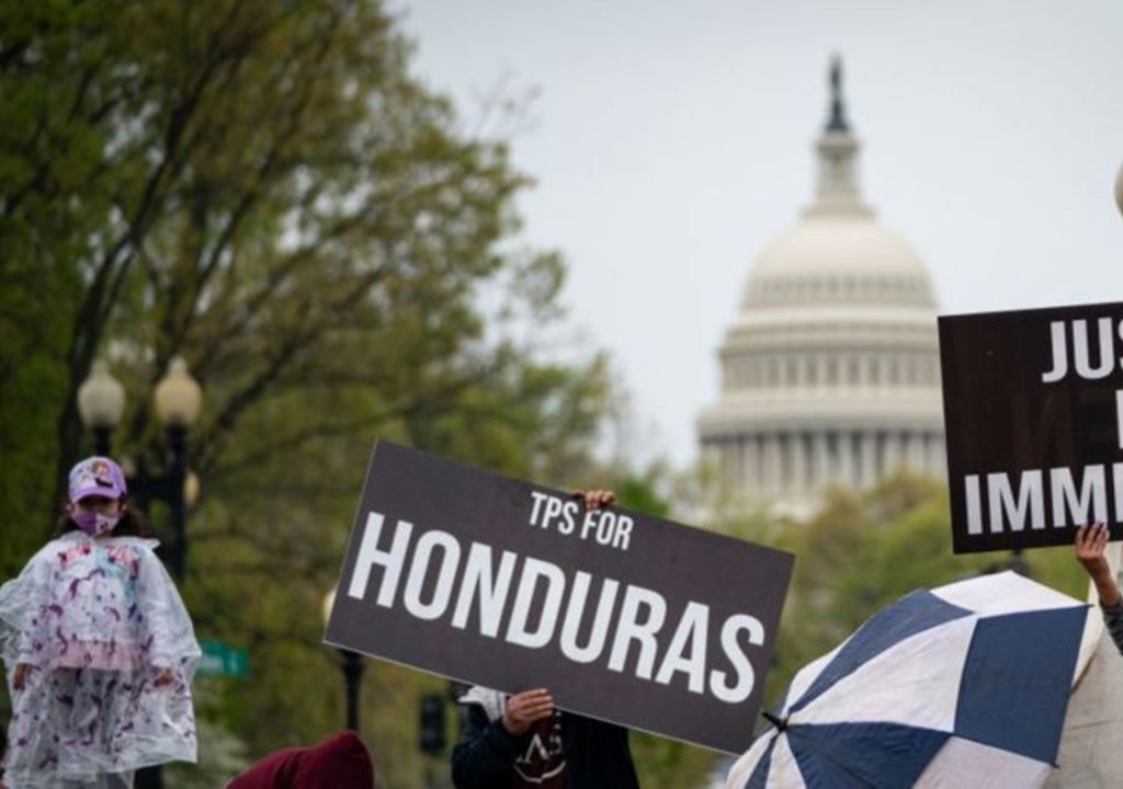 Personas levantando un cartel sobre el TPS