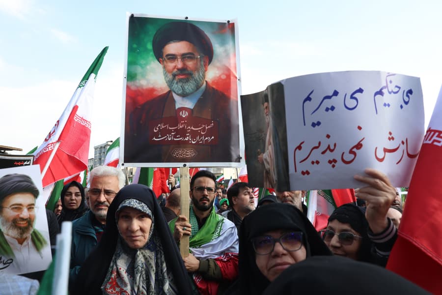 Personas levantando el cartel de Mojtaba Jameneí