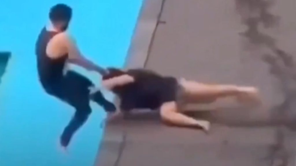 Hombre arrastrando a mujer hacia la piscina.