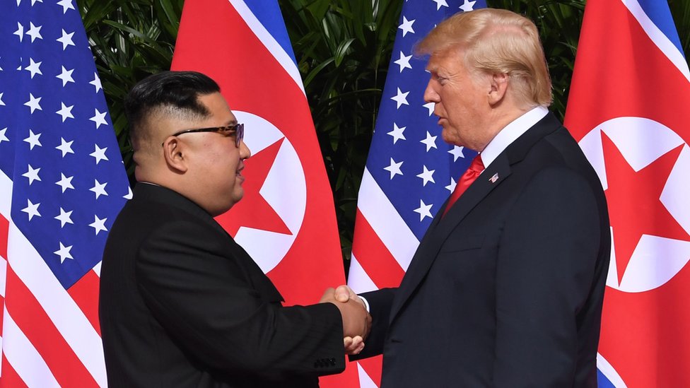 Donald Trump y Kim Jong-un dándose la mano